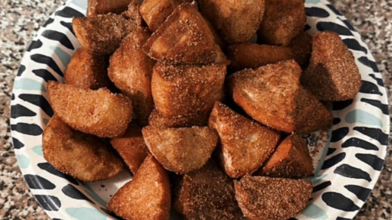 A pile of cinnamon sugar bagel bites in a black and white dish