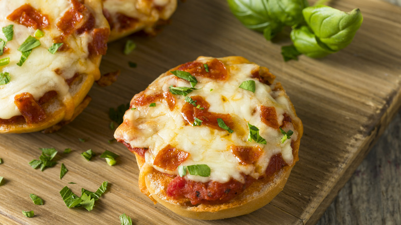 Homemade pizza bagels with pepperoni and basil