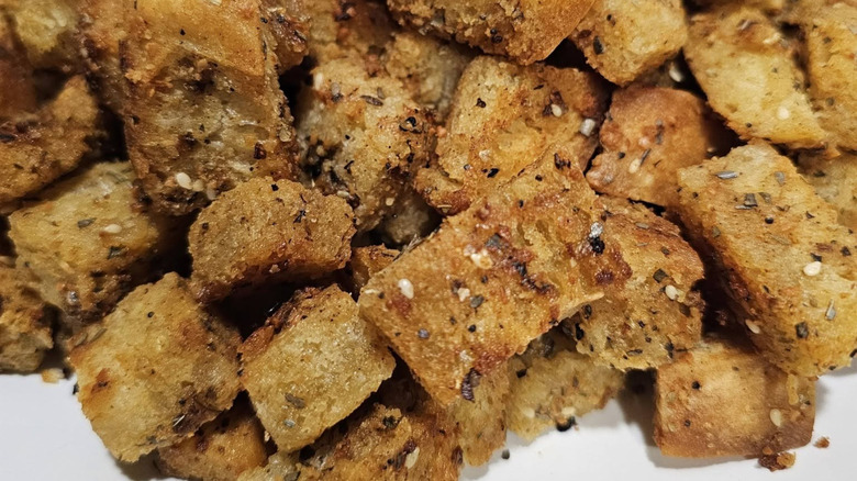 A crisp pile of croutons made from a leftover everything bagel on a plate