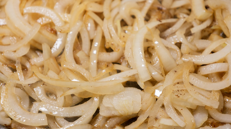 A closeup of sliced onions that are slightly brown and soft.