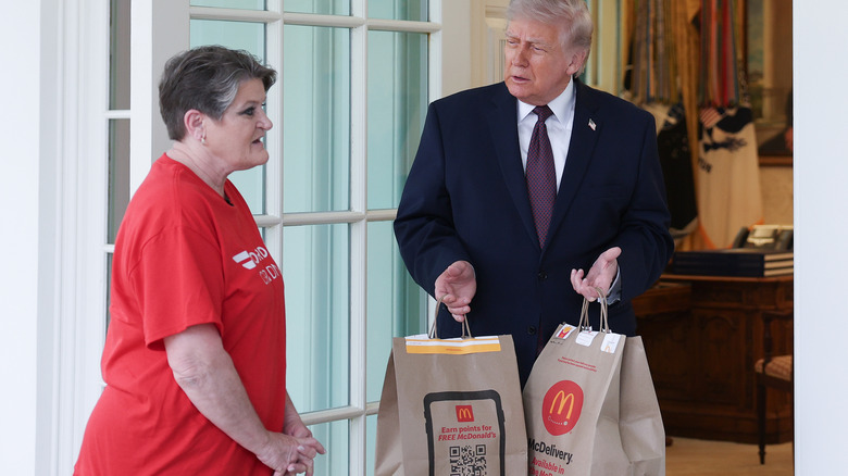 The DoorDash Grandma, Sharon Simmons, standing beside President Donald Trump as he holds two bags of McDonald's