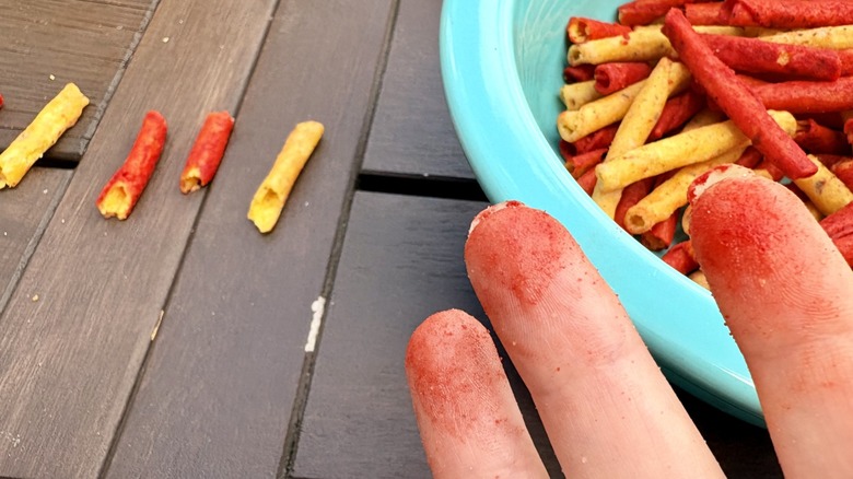 Doritos Dinamita classic and Simply NKD Chile Limon in a bowl with red flavor dusted fingers