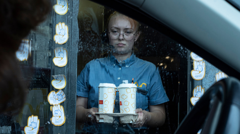 An unhappy drive-thru worker on a rainy day