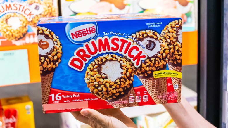 Hands holding up a box of Drumsticks