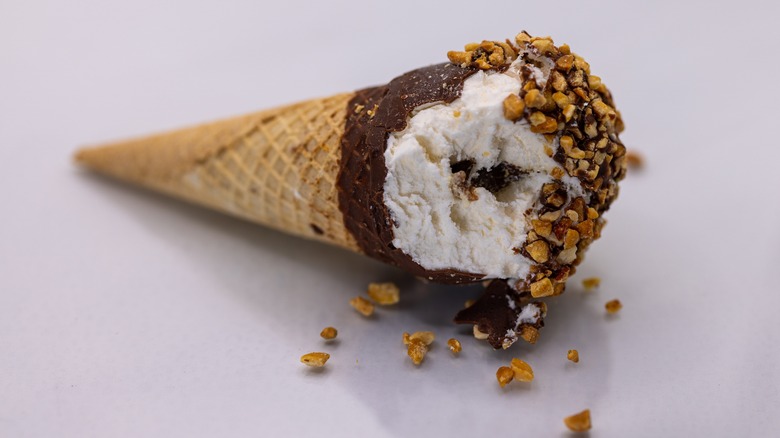 Drumstick ice cream laying on side with bite taken out