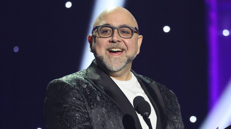 Duff Goldman in glasses smiling in front of microphone