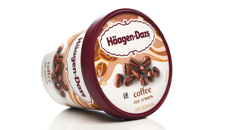 Pint of Haagen-Dazs coffee ice cream laying on its side against a white background