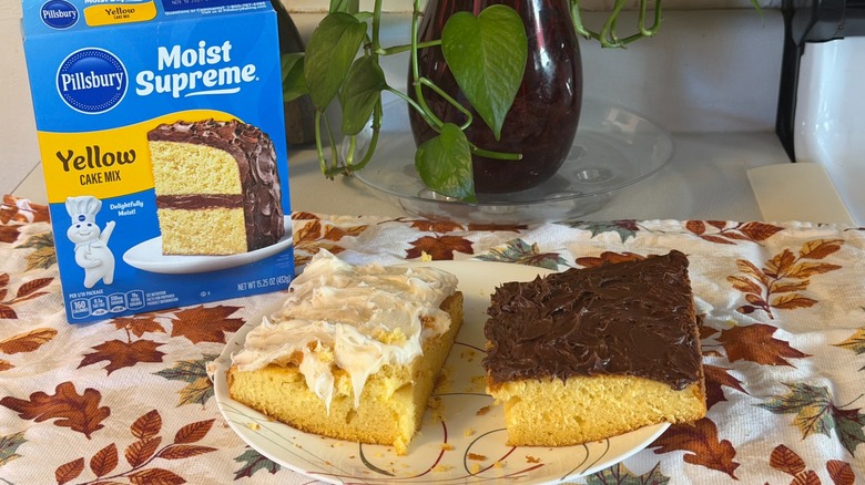 Two pieces of Pillsbury yellow cake, one with chocolate frosting, and one with cream cheese frosting on a plate in front of the box.