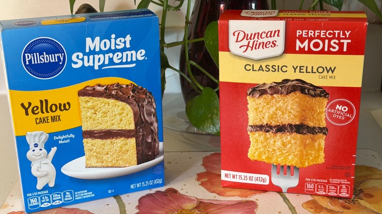A box of Pillsbury yellow cake mix next to a box of Duncan Hines yellow cake mix.