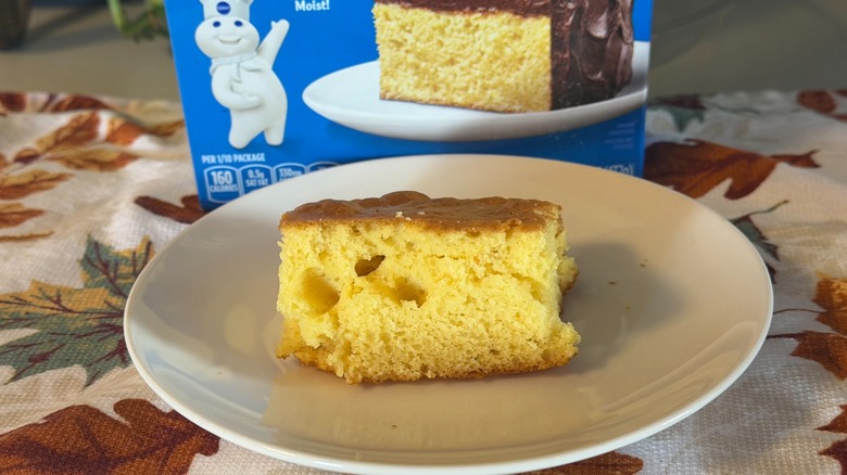 A piece of Pillsbury yellow cake with no frosting on a plate in front of the box.