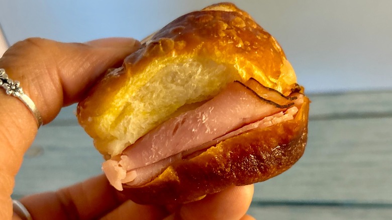 person holding Dunkin' Ham and Swiss Pretzel Sliders