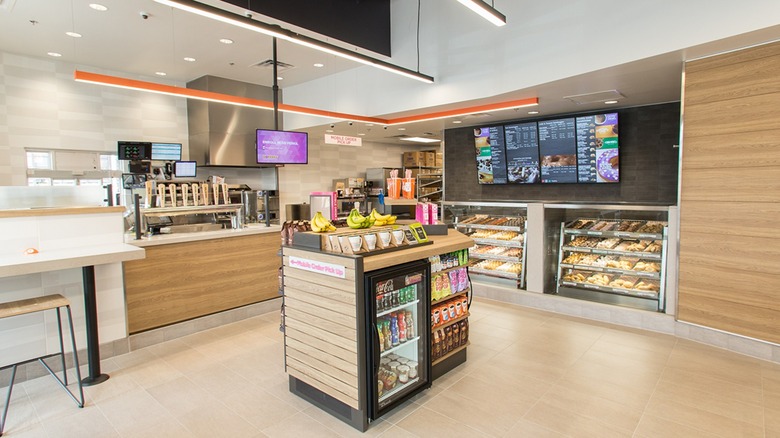 Inside of an empty Dunkin' store with all the lights on.