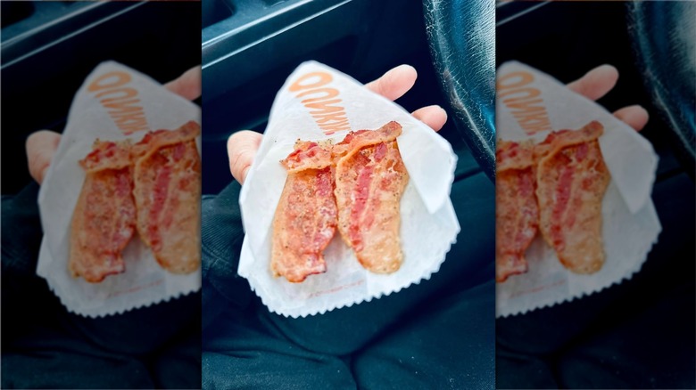 Hand holding bag of Snackin' Bacon