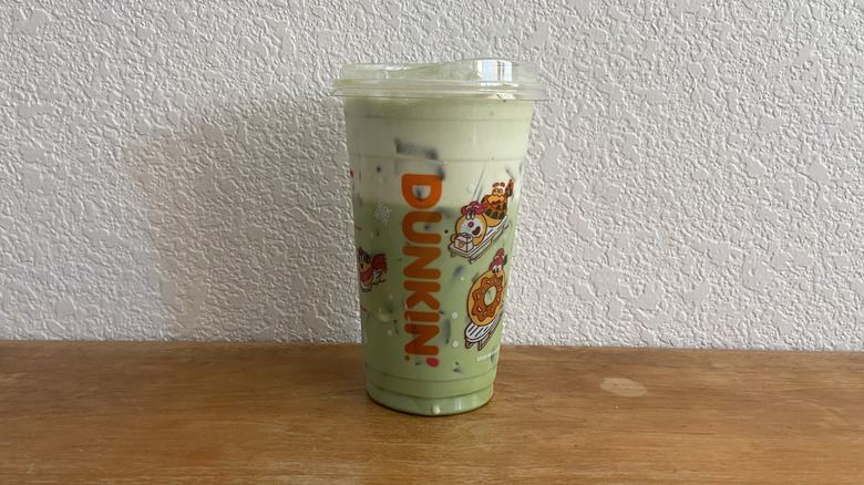 Almond Iced Protein Matcha Latte on wooden table.