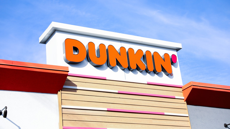 A Dunkin' sign on the side of a location's exterior.