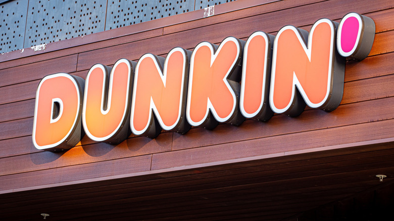 Dunkin' exterior sign on a wall with wood paneling