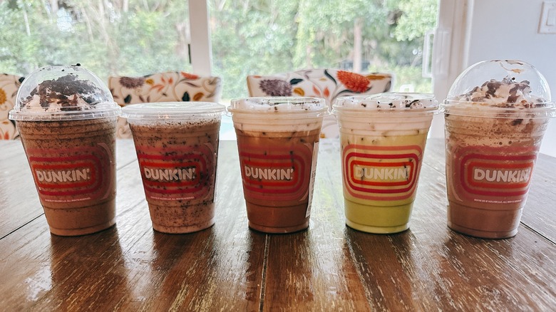 Five Dunkin' Oreo drinks on a wooden table