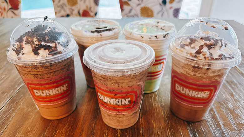 Five Dunkin' Oreo drinks on a wooden table