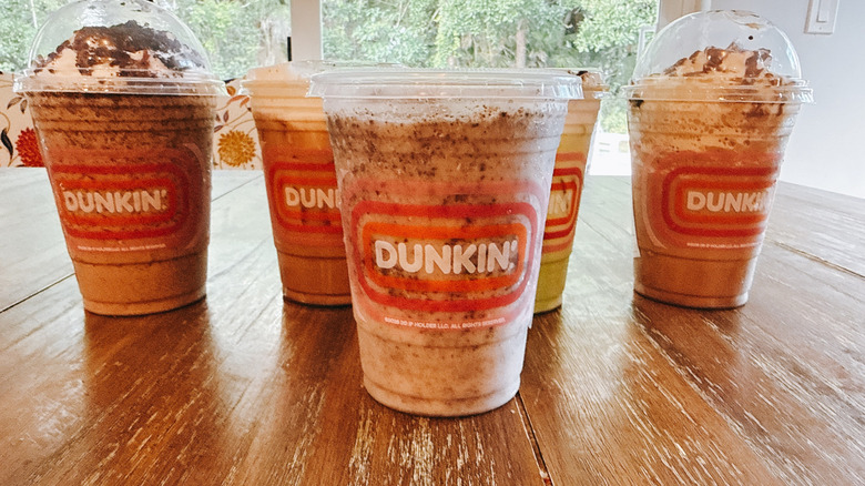 Dunkin's Oreo Coolatta with other drinks in background on wooden table