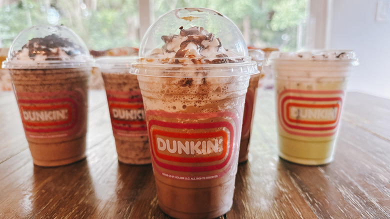 Dunkin's Oreo Triple Mocha Coffee Chiller with other drinks in background on a wooden table
