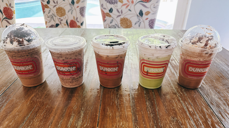 Five Dunkin' Oreo drinks on a wooden table