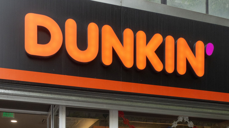 Exterior sign on a Dunkin' restaurant wall