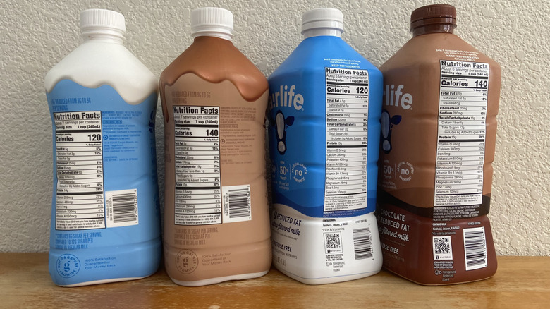 Four milk bottles with nutritional facts visible