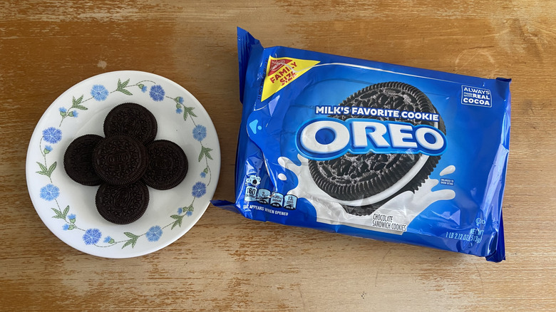 top-down view of Oreos on a small plate beside their packaging