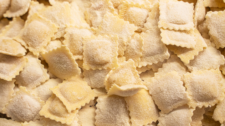 Fresh ravioli covered in flour and resting on a table