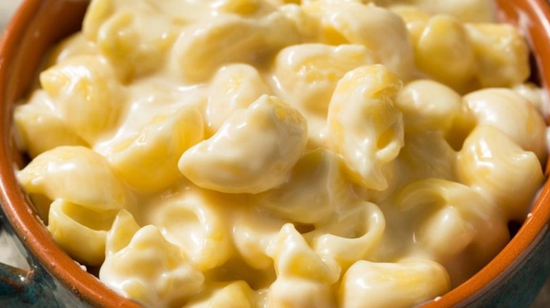 A closeup of creamy mac and cheese in an orange crock