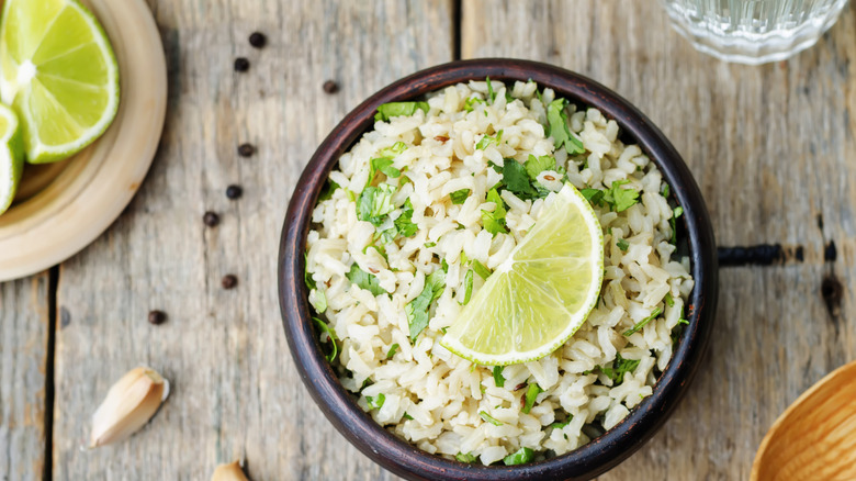 A bowl of white rice seasoned with chopped cilantro and lime