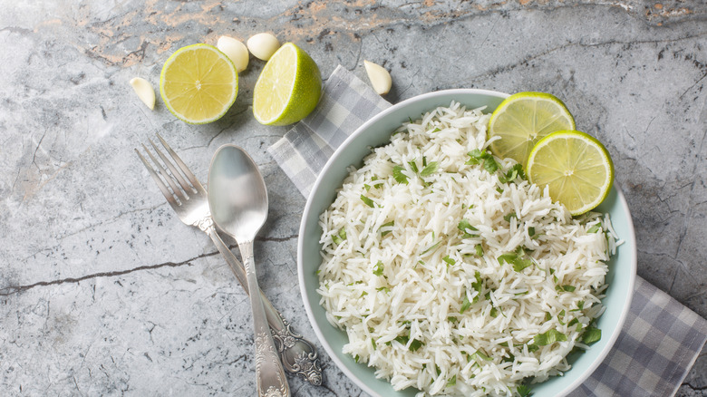 A bowl of cooked white rice with lime slices