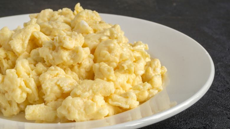 White plate of fluffy scrambled eggs