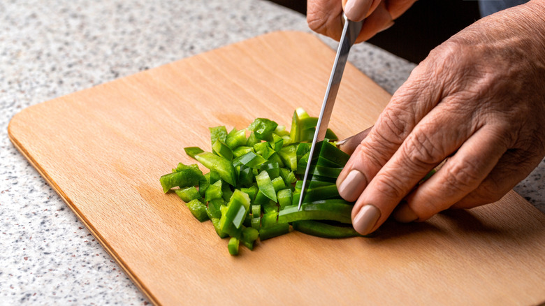 hands chopping green bell pepper