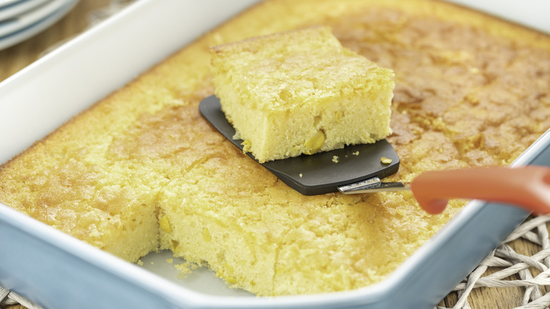 A single slice being removed from a pan of cornbread with a spatula