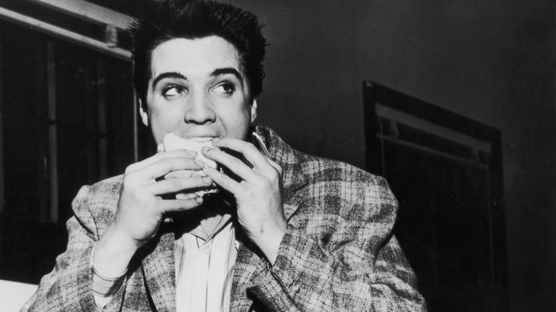 Elvis Presley eating a sandwich