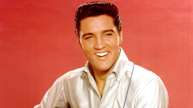 Smiling Elvis Presley with red background