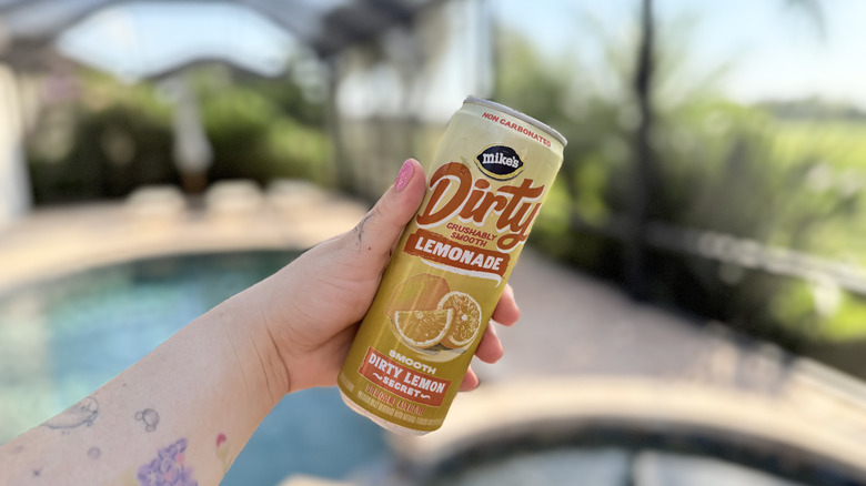 Hand holding a Mike's Dirty Lemonade can in Dirty Lemon Secret flavor