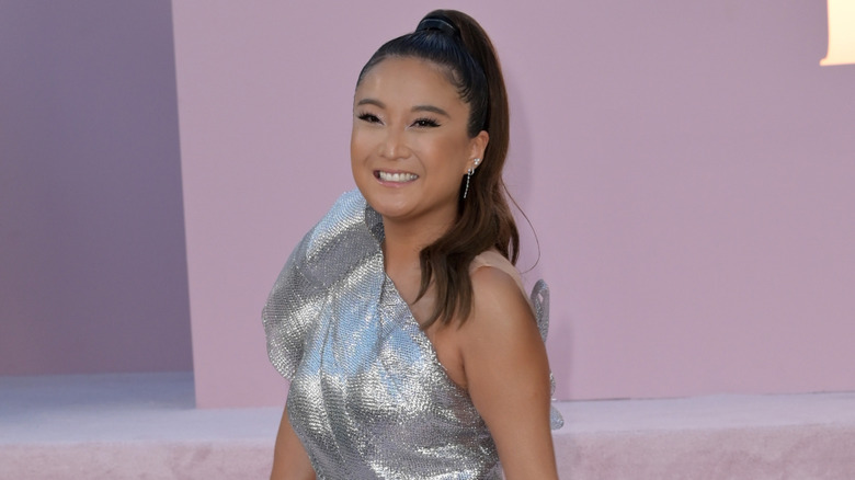 Ashley Park in one shoulder silver dress