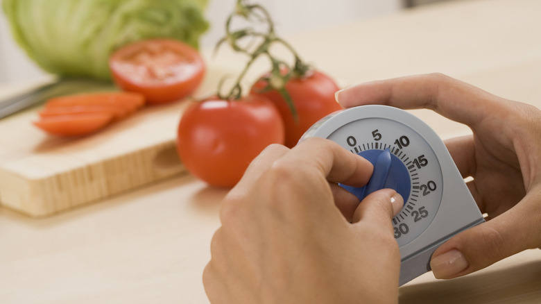 Hands setting manual timer in kitchen