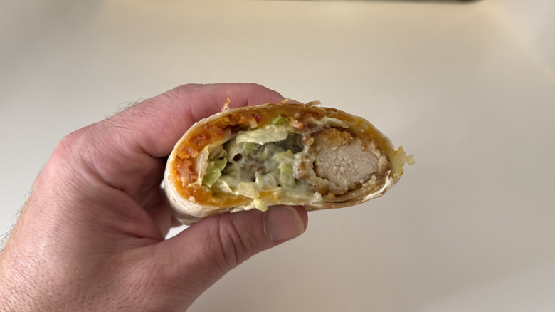 Taco Bell's Crispy Chicken Chipotle Bacon Melt Burrito in hand