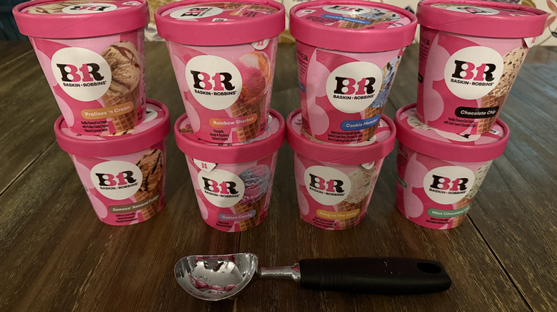Eight flavors of Baskin Robbins ice cream on a wooden table
