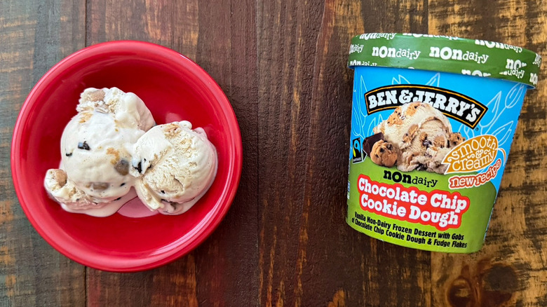 Two scoops of Ben & Jerry's Chocolate Chip Cookie Dough non-dairy ice cream next to a pint