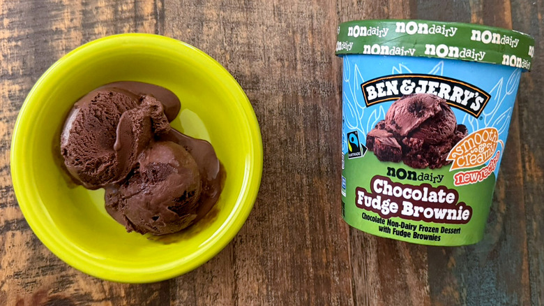 Two scoops of Ben & Jerry's Chocolate Fudge Brownie non-dairy ice cream next to a pint