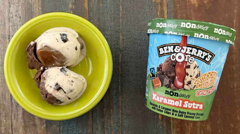 Two scoops of Ben & Jerry's Karamel Sutra non-dairy ice cream next to a pint