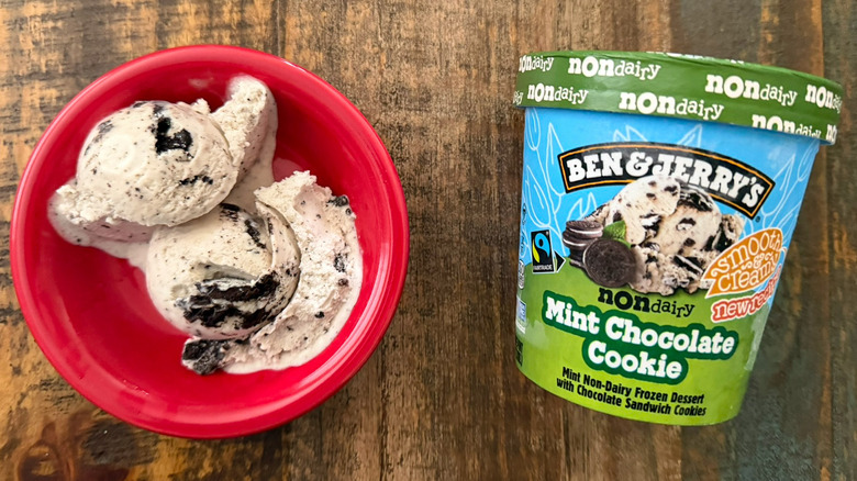 Two scoops of Ben & Jerry's Mint Chocolate Cookie non-dairy ice cream next to a pint