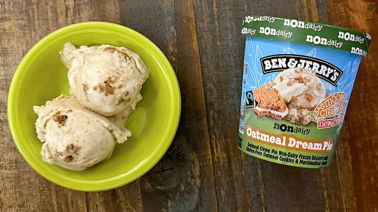 Two scoops of Ben & Jerry's Oatmeal Dream Pie non-dairy ice cream next to a pint
