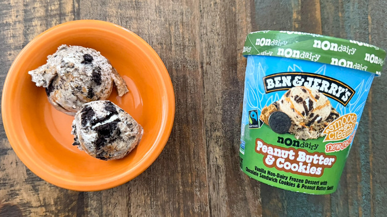Two scoops of Ben & Jerry's P.B. & Cookies non-dairy ice cream next to a pint