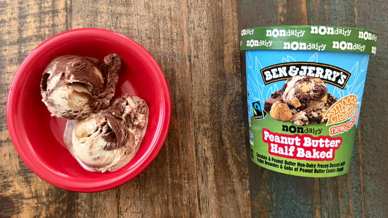 Two scoops of Ben & Jerry's Peanut Butter Half Baked non-dairy ice cream next to a pint