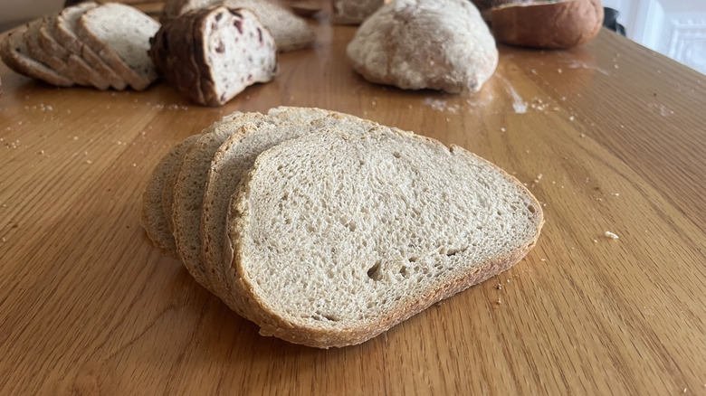 A sourdough boule is sliced and arranged on a counter